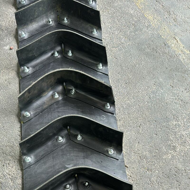 Tacos tipo chevron a medida para transporte inclinado de materiales.